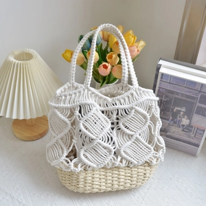Detailed weave of white cotton cord and beige straw on a large handmade bucket bag