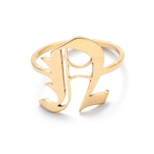 Detailed macro view of retro golden open ring featuring a large Gothic letter R design