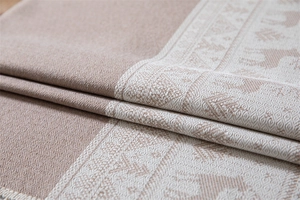 Close-up of reindeer pattern jacquard fabric showing soft texture and tassel detail