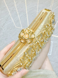 Detailed close-up of golden evening clutch featuring crystal rhinestones and metal flowers