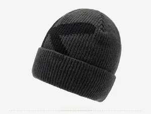 Detail of dark grey knit beanie with KXEKX woven label and ribbed texture