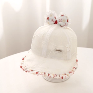 Détail du nœud floral et de la dentelle délicate sur un chapeau de soleil blanc pour bébé