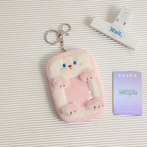 Close-up of pink and white plush card holder with soft texture and metal keychain