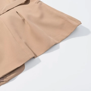 Detailed macro view of khaki woven fabric texture and precise stitching on sleeveless vest