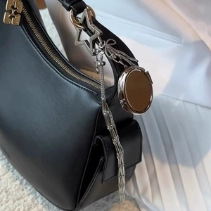 Silver lipstick pouch pendant on black leather shoulder bag with star charm and mirror