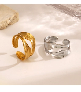 Close-up of irregular 18K gold and silver rings with brushed texture and organic wave design