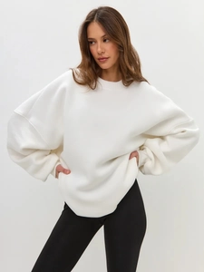 Detail of white oversized crewneck sweatshirt with dropped shoulders and thick fleece fabric