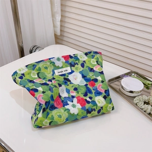 Detailed macro view of oil painting style floral makeup bag with simple wish label