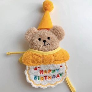 Detailed view of plush teddy bear with Happy Birthday embroidery and a yellow party hat