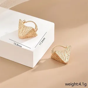 Detailed macro view of gold-textured irregular triangular earrings with fine mesh pattern