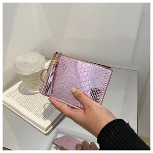 Pink crocodile pattern PU leather card holder with metallic tassel held by a hand