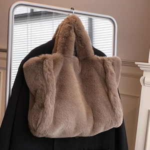 Grand sac cabas marron en peluche avec chaîne suspendu sur un cintre avec une veste noire