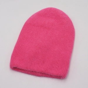 Gros plan détaillé du bonnet en mohair rose montrant la texture douce et les mailles