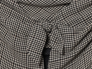 Detailed macro shot of the black and white houndstooth dress featuring a bow knot design