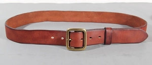 Detailed macro view of vintage brown genuine leather belt with antique brass buckle