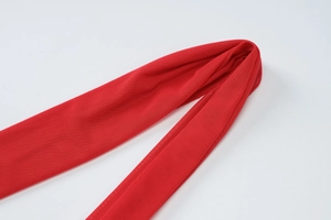 Detailed macro view of the bright red fine mesh fabric and layered fold texture