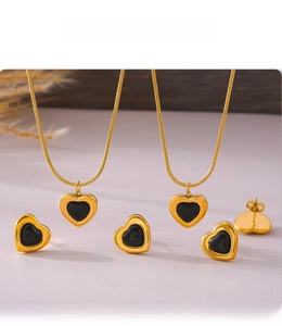 Detail of PVD plated black heart necklace and stud earrings set with gold snake chains