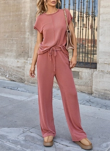 Close-up of rust-colored ribbed knit fabric texture on casual top and drawstring pants