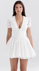 Détail de la broderie en dentelle blanche à col en V et manches bouffantes élégantes