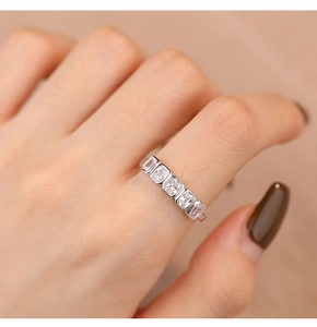 Detailed view of silver ring with five sparkling rectangular crystals on a model's hand