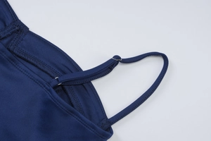 Detail of adjustable shoulder strap and metal buckle on navy blue summer sundress