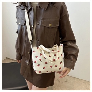 Cream corduroy tote bag with red strawberry pattern and adjustable shoulder strap