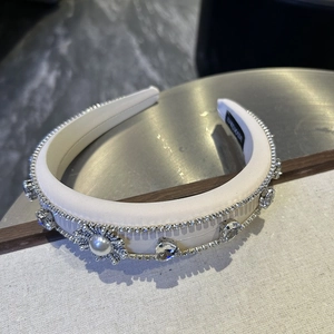 Macro detail of handmade satin headband with sparkling rhinestones and pearl flower decor