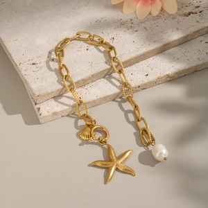 Bracelet océan en acier doré avec breloques étoile de mer, coquillage et perle blanche