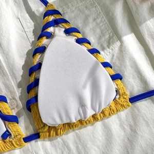 Détail du haut de bikini en seersucker jaune avec laçage bleu et coussinets amovibles