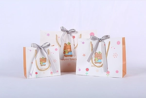 Three sizes of cartoon bear gift bags with grey satin ribbons and woven gold handles