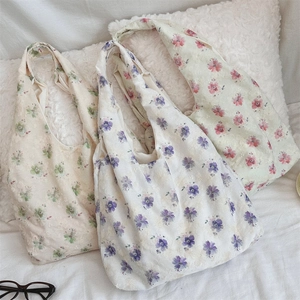 Close-up of floral embroidery canvas tote bags in green, purple, and pink floral patterns