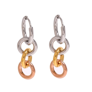 Gros plan de boucles d'oreilles entrelacées tricolores en argent, or et or rose poli