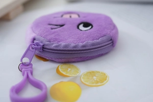 Close-up of a purple plush emoji coin purse with a winking face and plastic hook