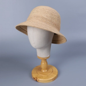 Elegant hand-woven beige raffia straw sun hat with round dome and minimalist texture