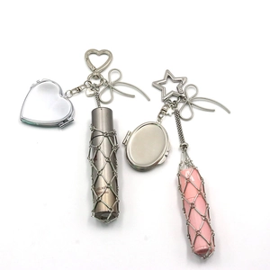 Detail view of the metal mesh lipstick holder keychain with mirror and bow charm