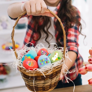 Close-up of Easter basket with colorful decorated eggs and Happy Easter stickers