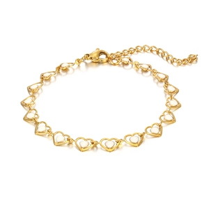Detail of bohemian gold heart chain bracelet with white enamel inlays and lobster clasp