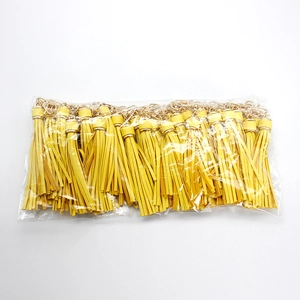 Bulk pack of yellow faux leather tassels with gold metal clasps in a clear polybag