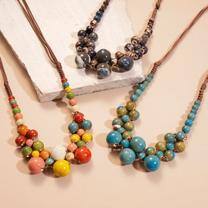 Détail de trois couches de colliers tissés bohèmes avec des perles en céramique colorées