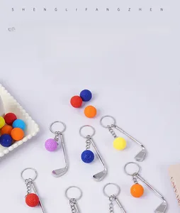 Close-up of mini metal golf club pendants with colorful balls for keychain gift