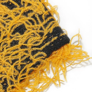 Close-up of fuzzy yellow and black knit fabric with soft texture and hairy fibers