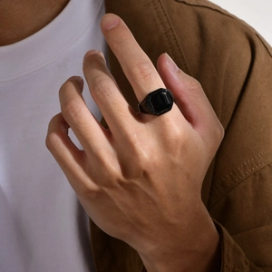 Polished black stainless steel signet ring with octagonal design worn by a male model