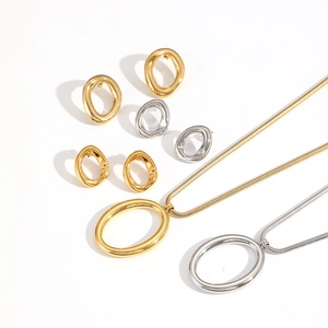 Macro shot of minimalist gold and silver oval-shaped jewelry set with necklaces and earrings