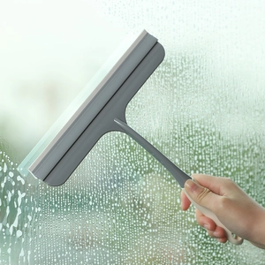 Non-slip glass squeegee window cleaner tool being used on a wet glass surface