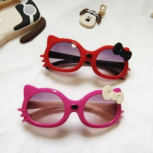 Red and pink cat-ear sunglasses for kids featuring cute bow details on white fabric
