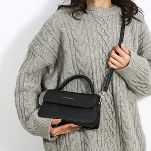Elegante borsa a mano in pelle nera PU con dettagli dorati indossata da modella