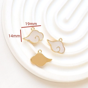 Macro detail of gold-plated lucky cloud pendant with white enamel inlay for DIY jewelry