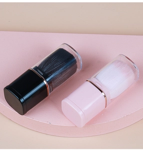 Close-up of portable retractable makeup brushes in pink and black with protective caps