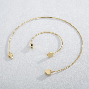 Detailed set of gold titanium steel open collar and bracelet with heart and cross motifs