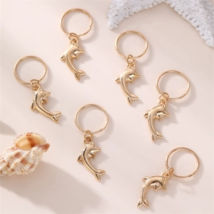 Golden dolphin hair rings set for braids with a polished metallic finish on pink background